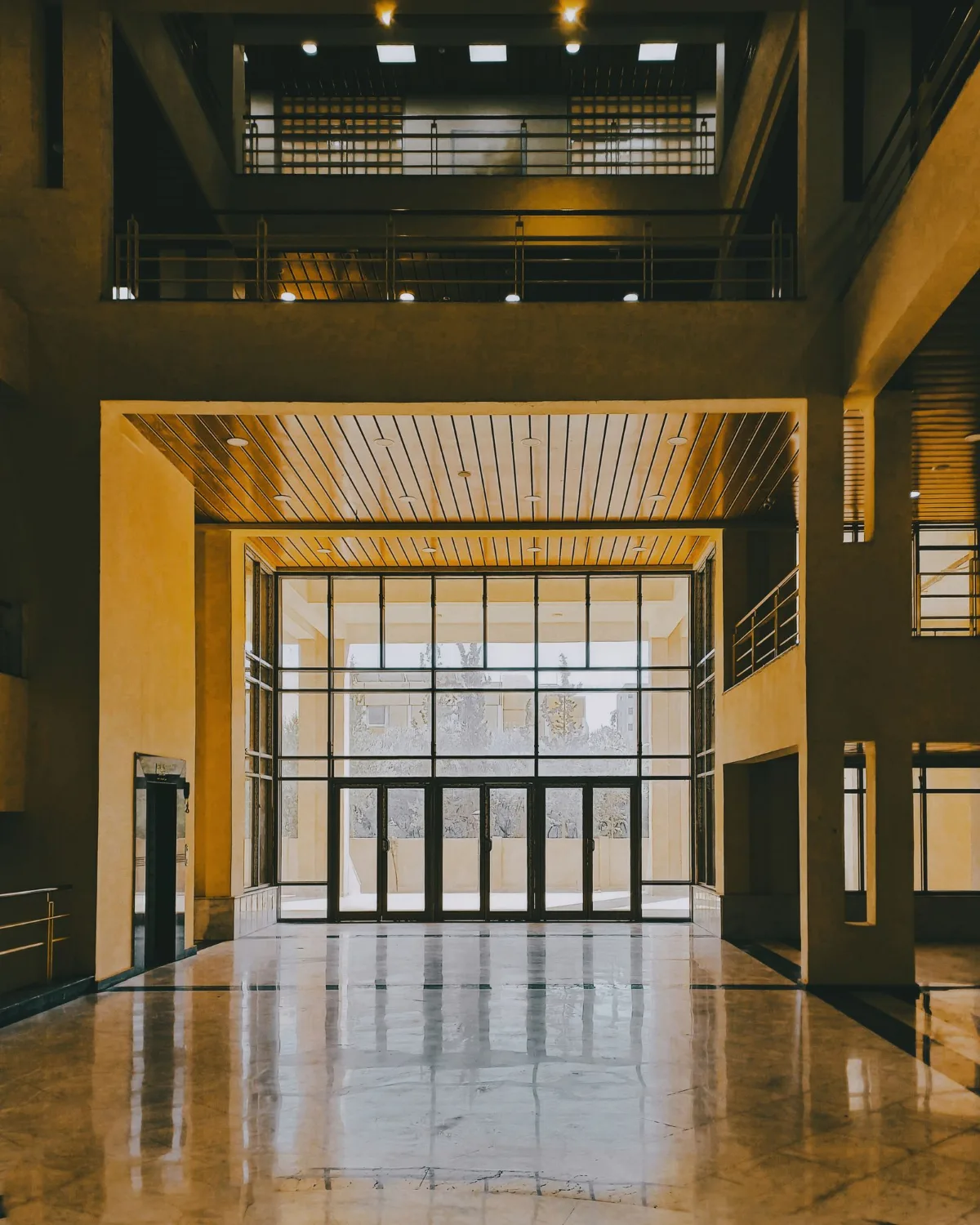 Hall amplio con luz cálida y ventanales.