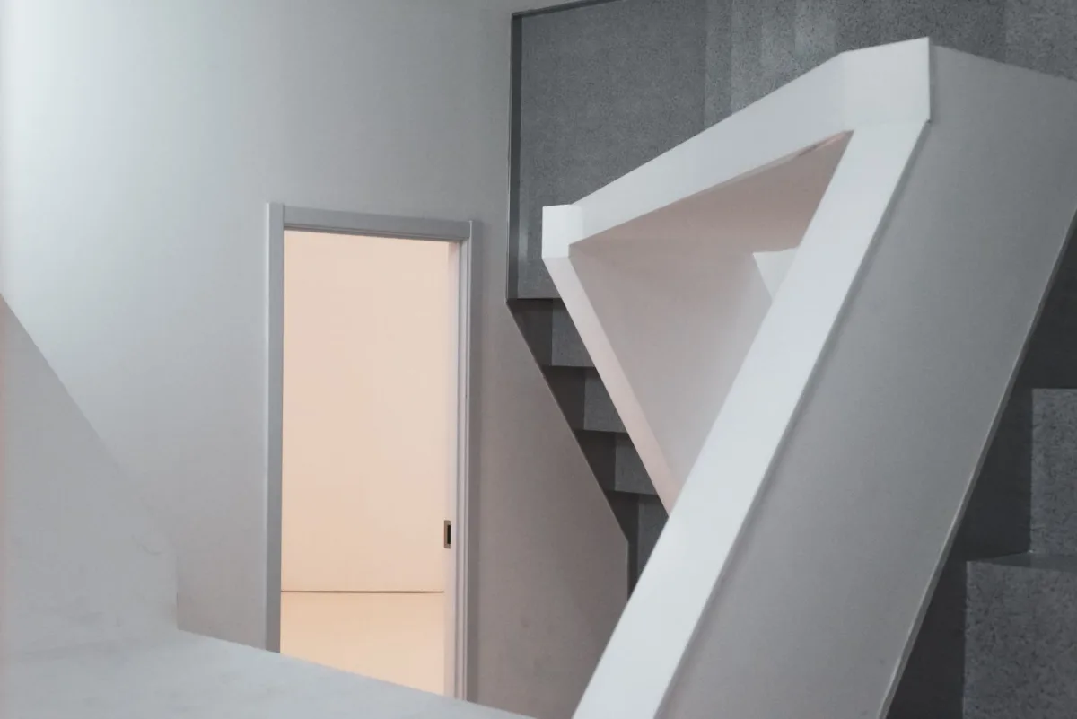 Interior blanco con una puerta iluminada.
